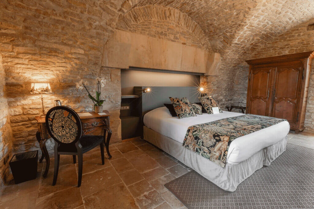 Charming room with exposed stone vault at the Hôtel de la Ranconniere in Normandy