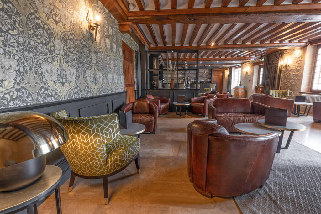 Club en cuir et fauteuil moderne du bar de l'hotel de charme Ferme de la Rançonniere en Normandie