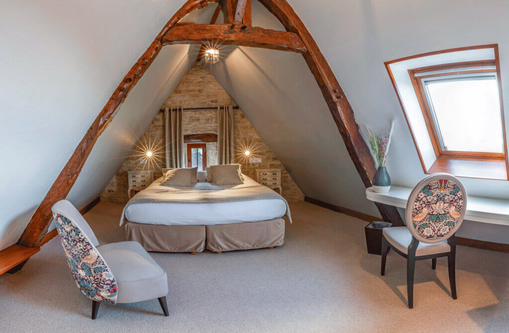 Chambre cosy avec poutres apparentes, idéale pour séjour en amoureux à l'hotel Ferme de la Ranconniere en Normandie