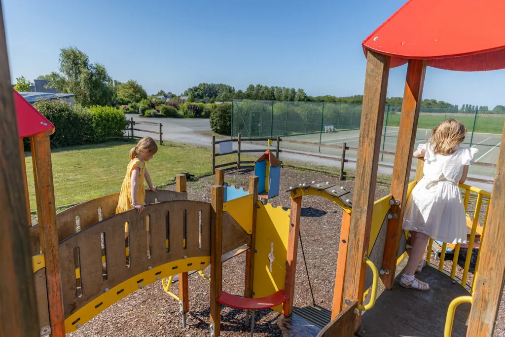 Des enfants s'amusent dans l'aire de jeux de l'hotel Ferme de la Ranconniere kid friendly en Normandie