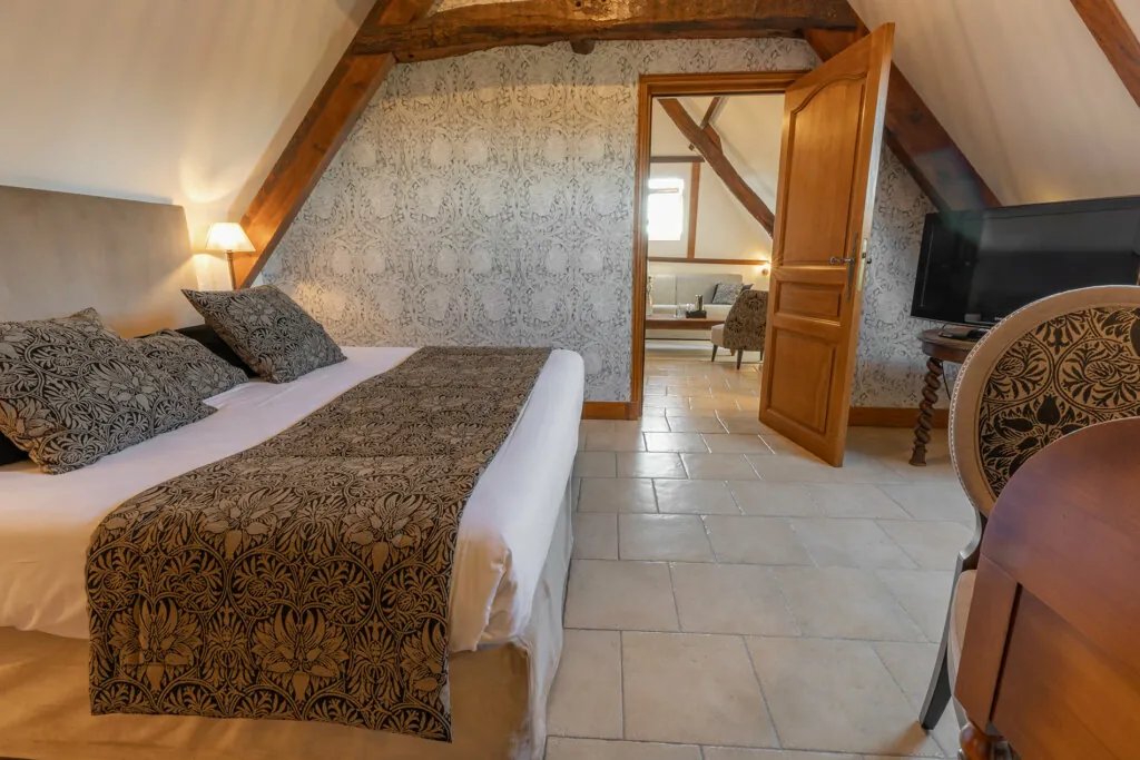 Chambre avec lit double et grand ecran de l'hotel Ferme de la Ranconniere en Normandie